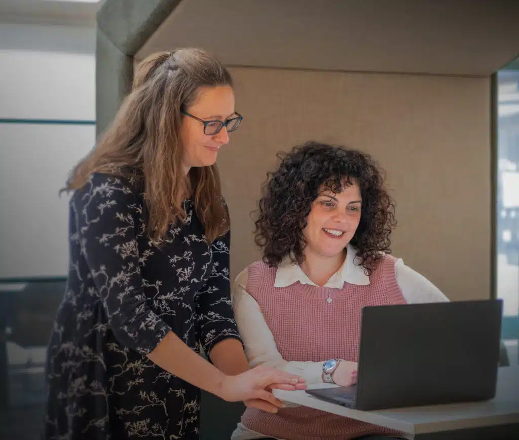 Two women working at JBA, looking at a laptop, highlighting career opportunities to join a team dedicated to building global resilience | JBA Global Resilience.