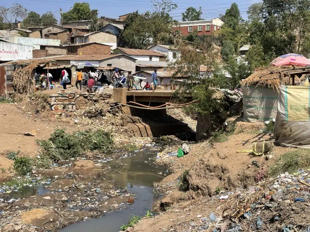 Damaged bridge and waste in a waterway in Malawi after Cyclone Freddy, highlighting JBA’s expertise in strategic investment planning to build resilient infrastructure and reduce disaster impacts | JBA Global Resilience.