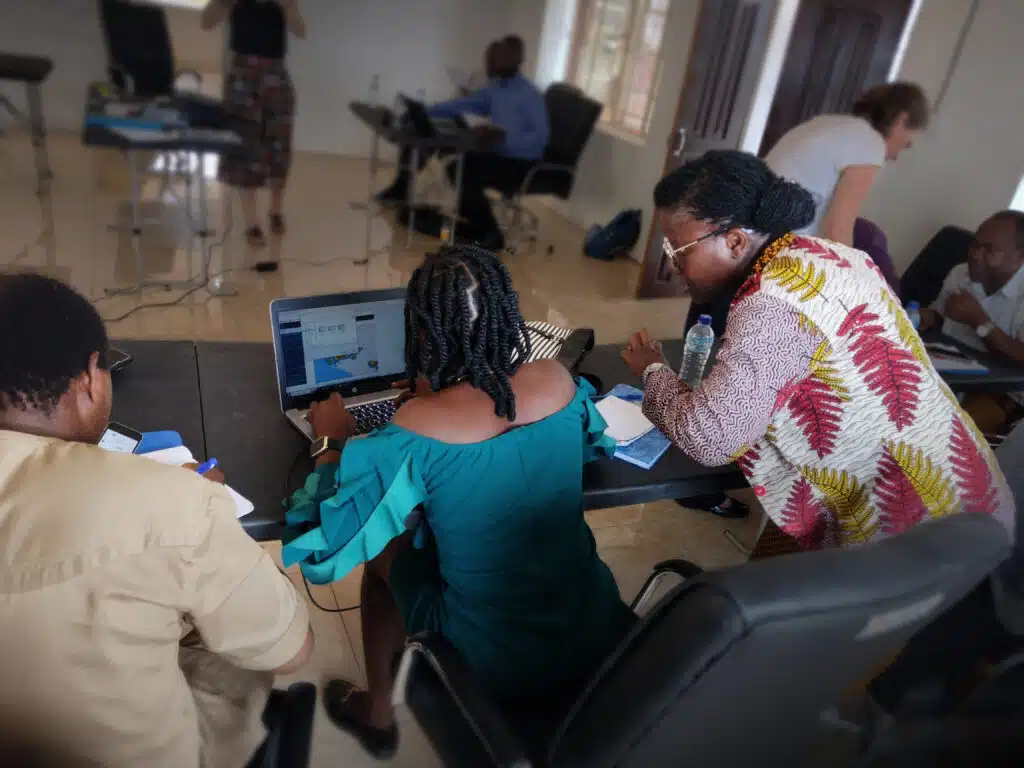 Partners working together in a room with computers, illustrating JBA Global Resilience’s network of trusted collaborators building climate and disaster resilience | JBA Global Resilience.