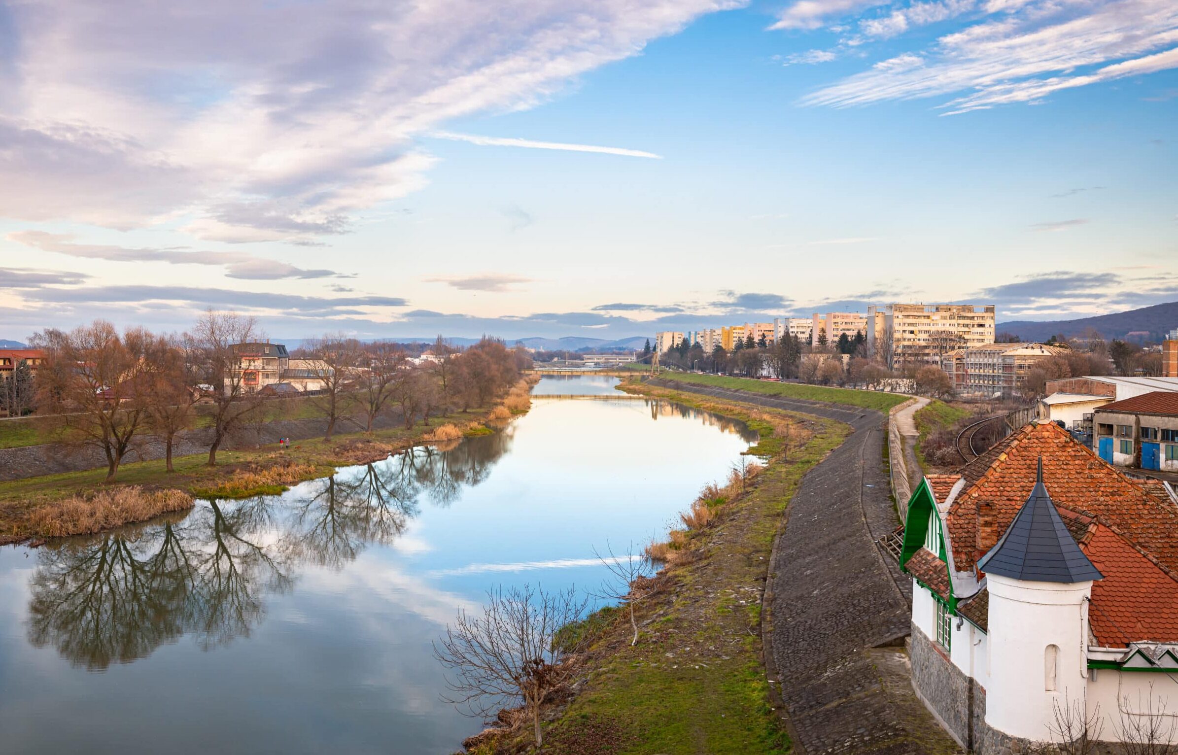 View of the calm waters of the Mures River in the city of Târgu Mureș in Transylvania, Romania. View is from a bridge over the river.