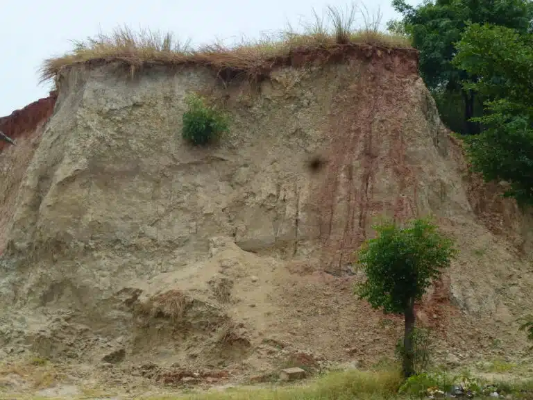 Steep sided, deep riverbank. Illustrating layers of sediment and erosion | JBA Global Resilience