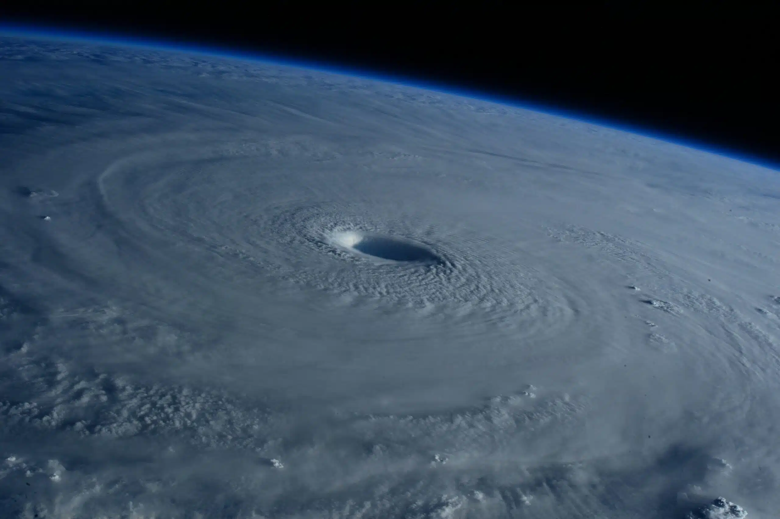Satellite image showing a powerful tropical cyclone over the ocean, with a clearly defined eye and spiral cloud bands approaching land.