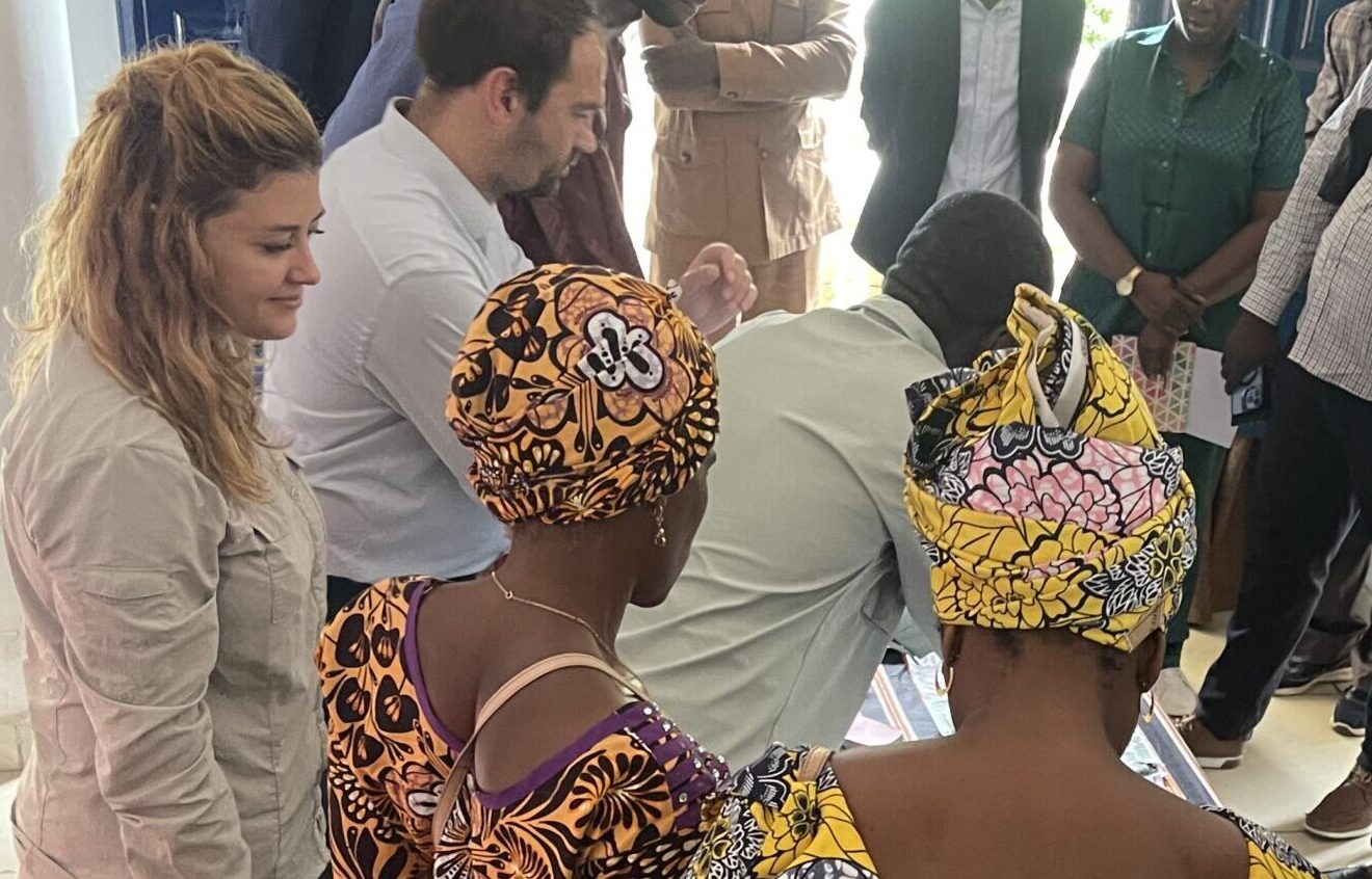 Group of people standing closely together indoors, taking part in a facilitated workshop.