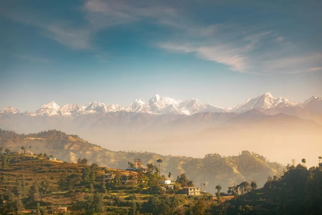 View of the Himalayan mountain range above terraced landscapes and rural settlements in Nepal.